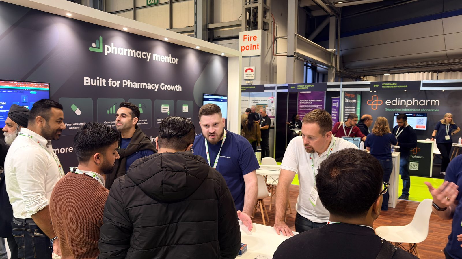 Pharmacy owners and visitors in conversation with the Pharmacy Mentor team at the 2026 show
