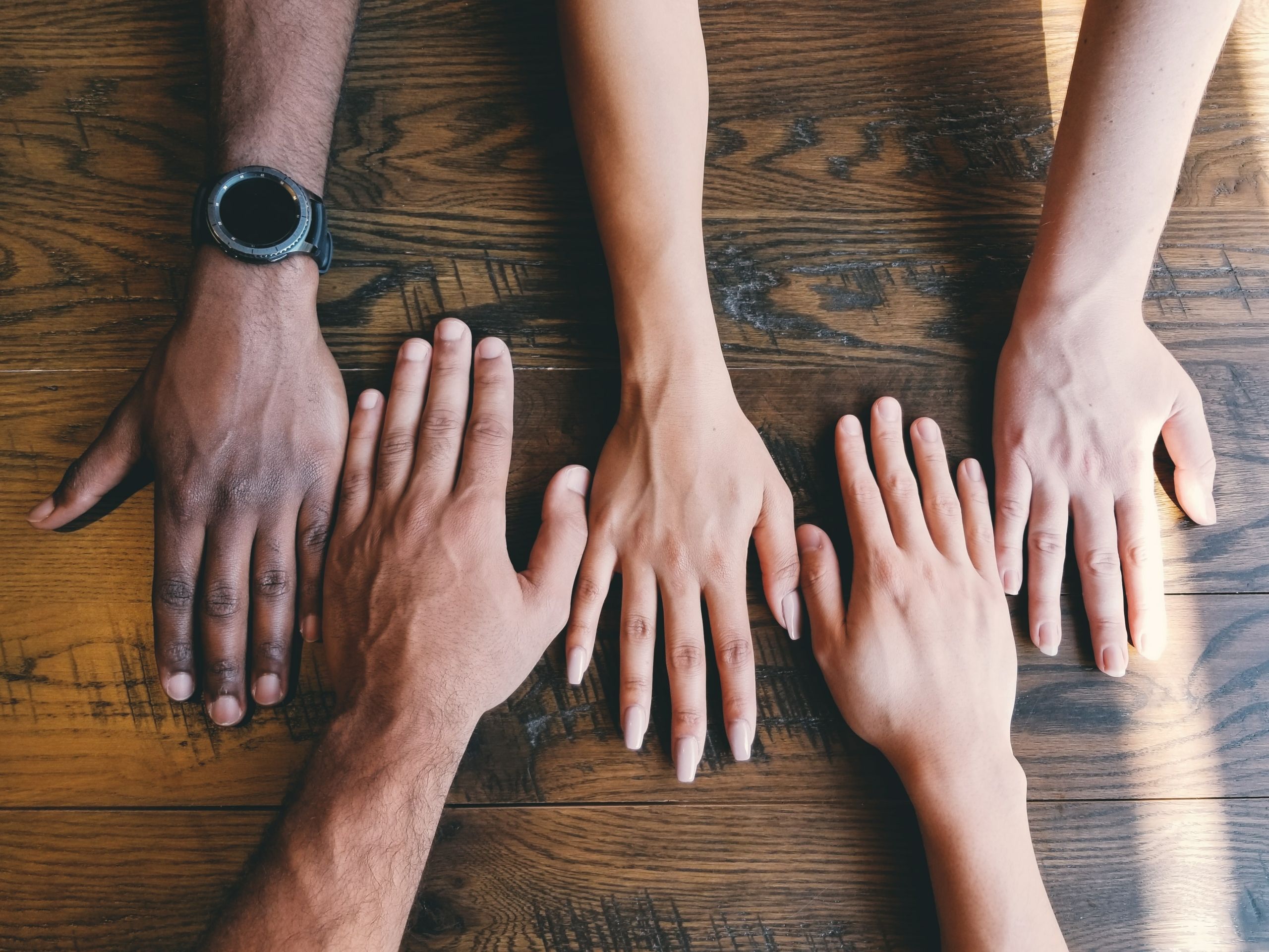 hands on a table signifying team culture