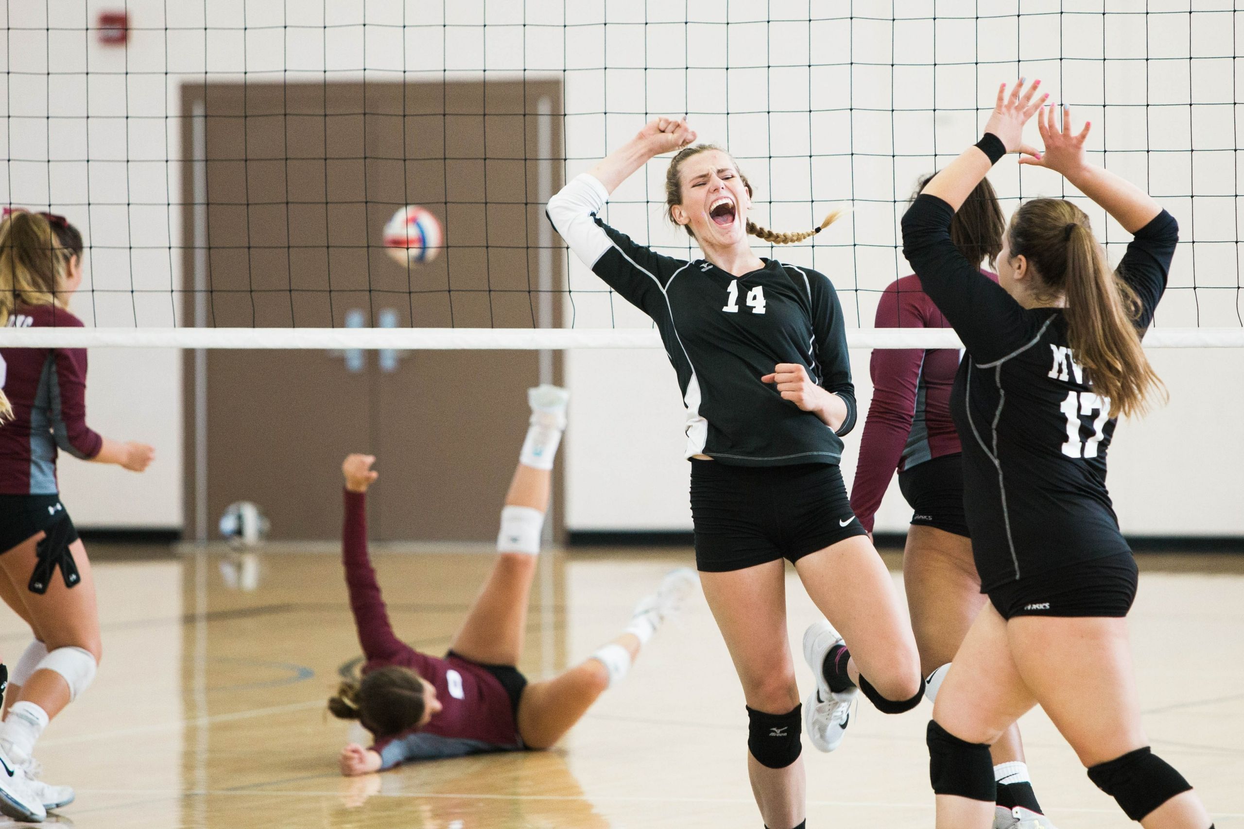girls playing volleyball in a sports hall
